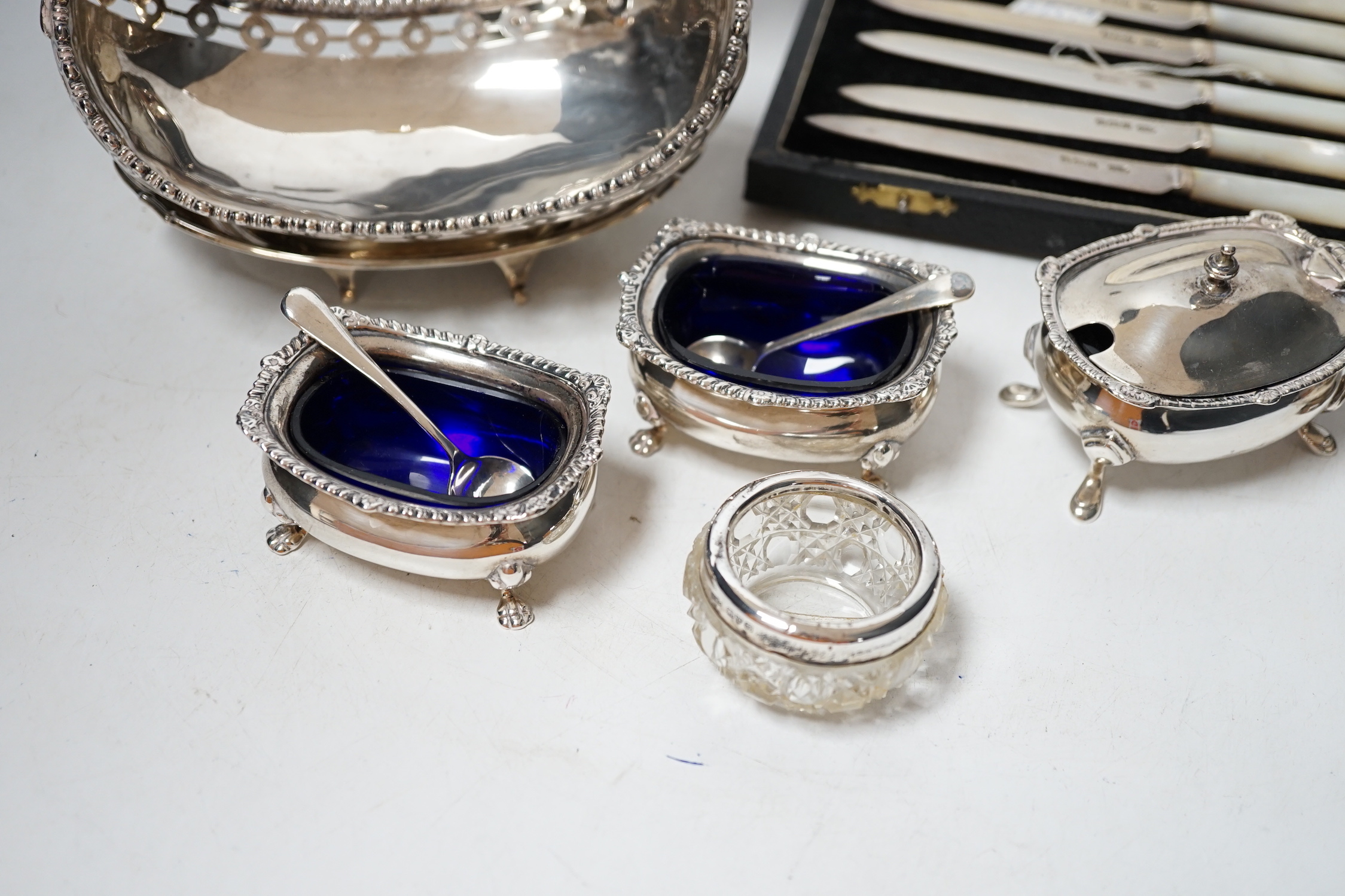 An Edwardian small silver two handled pedestal dish, London, 1902, height 12cm, a silver inkstand base, a silver boat shaped dish (lacking stand), a pair of silver salts with blue glass liners and spoons, three other sil